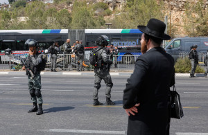<p>A man stands as Israeli security personnel secure the scene where a suspected shooting attack took place at the outskirts of Jerusalem, September 8, 2025 REUTERS/Ammar Awad</p>
