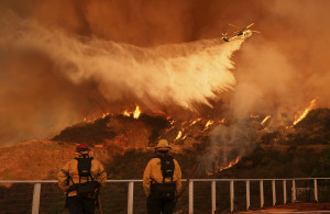 <p>Firefighters watch as water is dropped on the Palisades Fire in Mandeville Canyon Saturday, Jan. 11, 2025, in Los Angeles. (AP Photo/Jae C. Hong)</p>