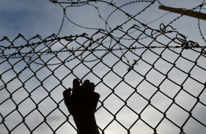 <p>A person holds a fence at the Rafah border, as Hamas militants are expected to release hostages abducted by Hamas during the October 7 attack on Israel, as part of a hostages-prisoners swap deal between Hamas and Israel, seen from southern Gaza Strip, November 25, 2023. REUTERS/Ibraheem Abu Mustafa</p>