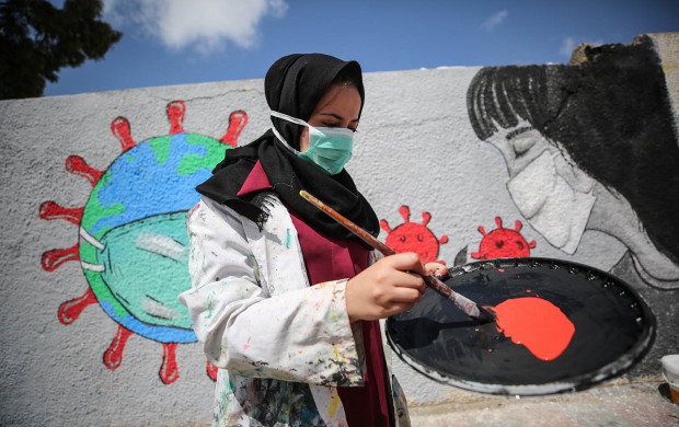 <p>Palestinian painters work on a mural to draw attention to the novel coronavirus pandemic in Khan Yunis, Gaza, on March 28. Mustafa Hassona/Anadolu Agency via Getty Images</p>