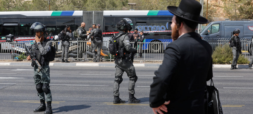 <p>A man stands as Israeli security personnel secure the scene where a suspected shooting attack took place at the outskirts of Jerusalem, September 8, 2025 REUTERS/Ammar Awad</p>